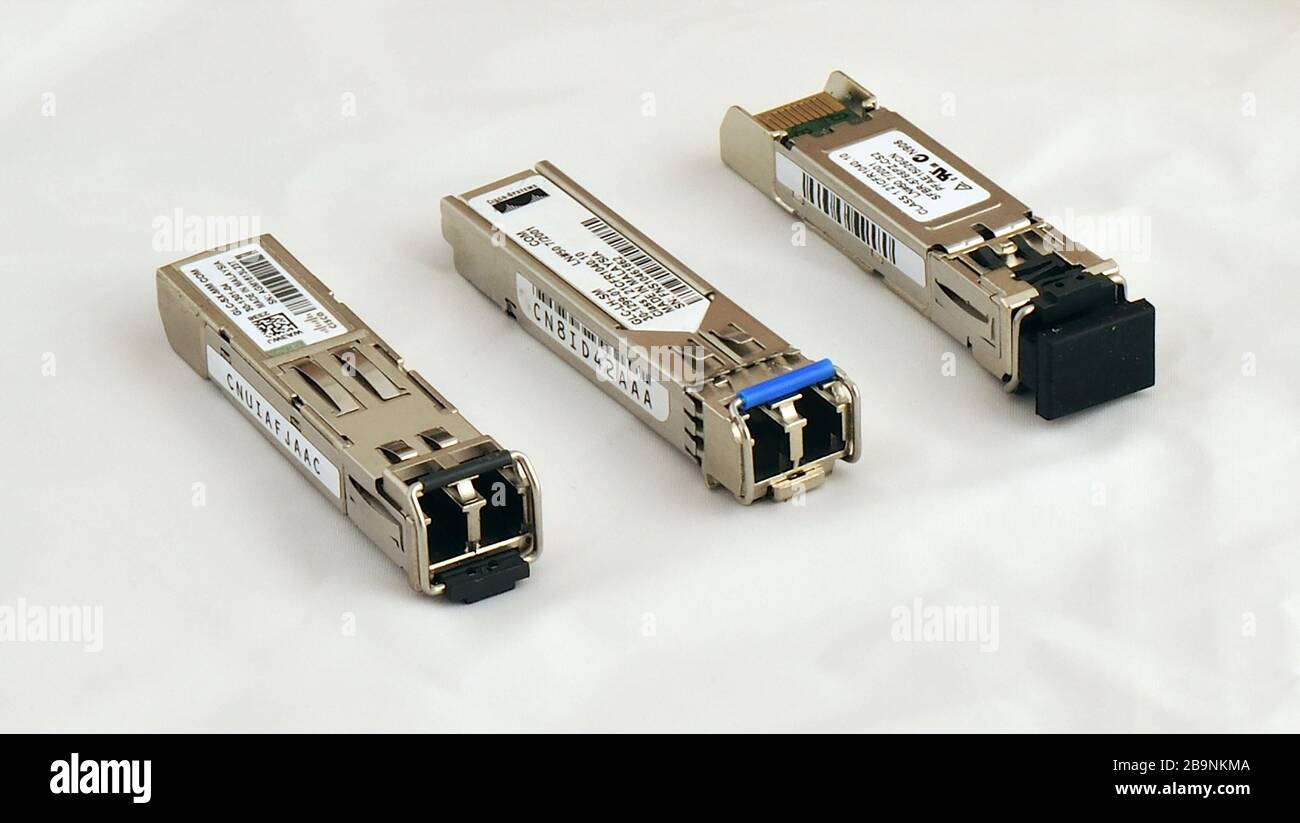 Three Cisco fibre optic SFP transceivers, data network communications equipment. Stock Photo