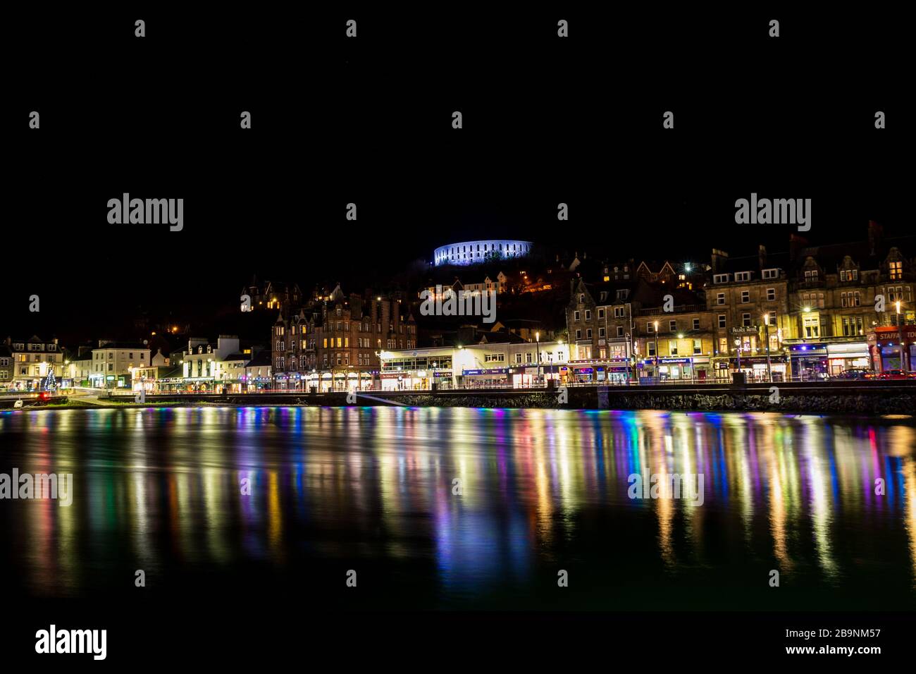 Night city lights reflected in water of Scottish coastal town Oban Stock Photo