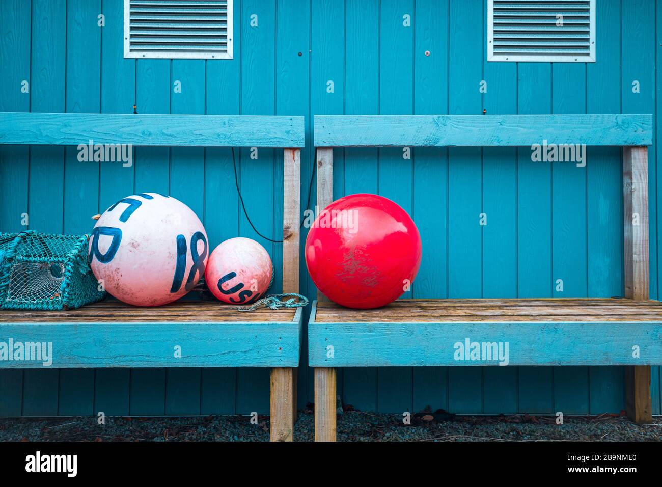 Outdoor still life - marking buoys and crab trap on wooden blue bench by the costal house in Scotland Stock Photo