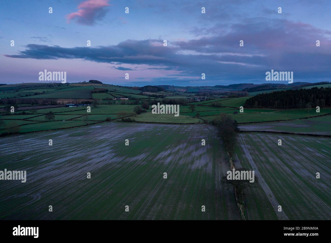 Colourful twilight sky over green farming fields in Shropshire, UK - drone point of view Stock Photo