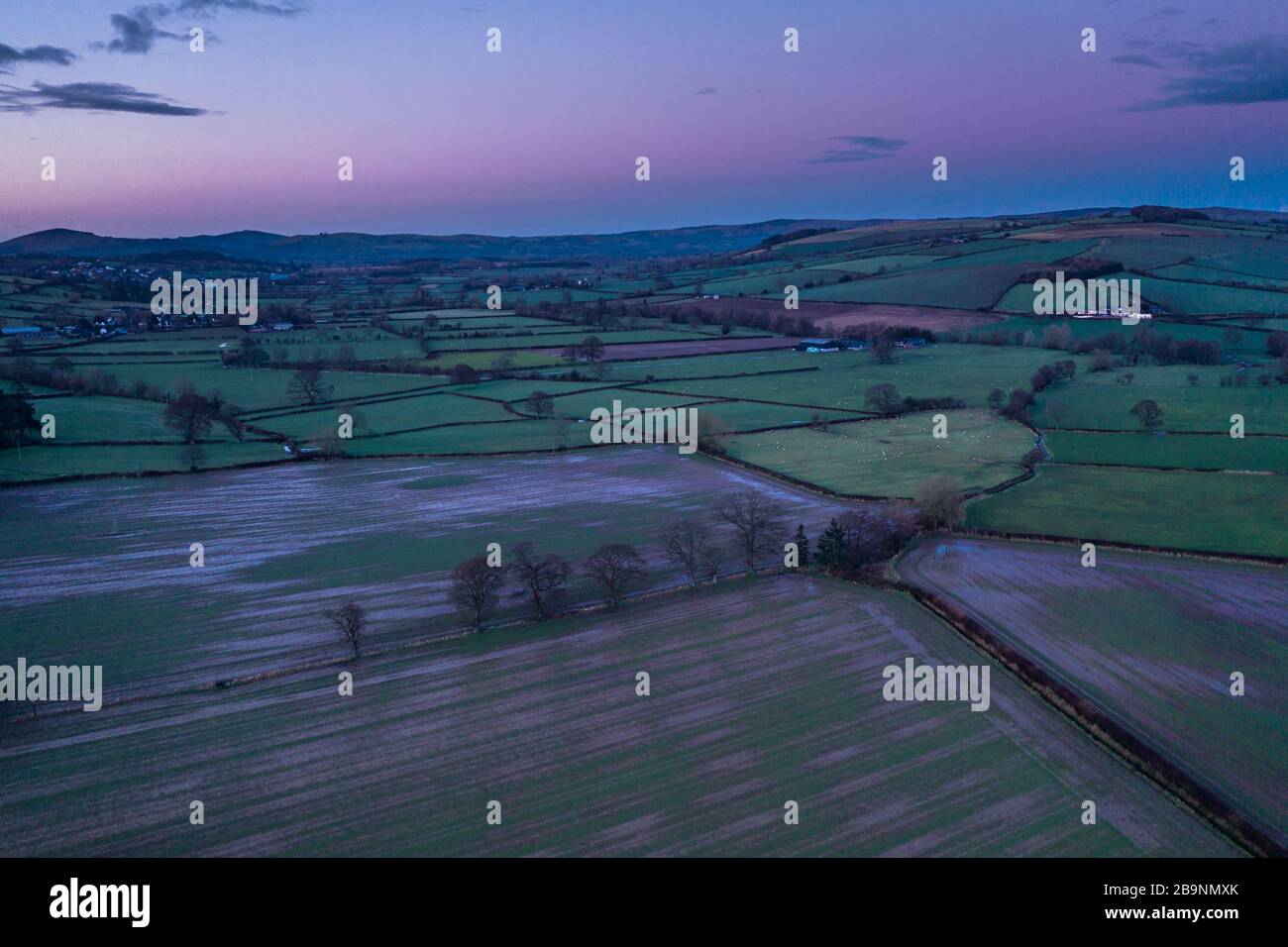 Colourful twilight sky over green farming fields in Shropshire, UK - drone point of view Stock Photo