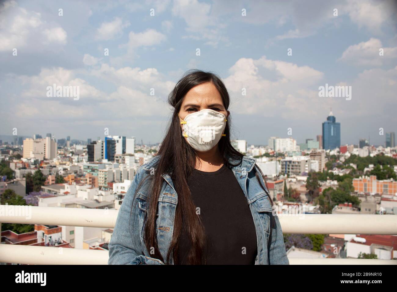 use mask covering nose and mouth for a Mexican woman sick with influenza, coronavirus, bacteria, long hair between 40 and 45 years in Mexico City Stock Photo
