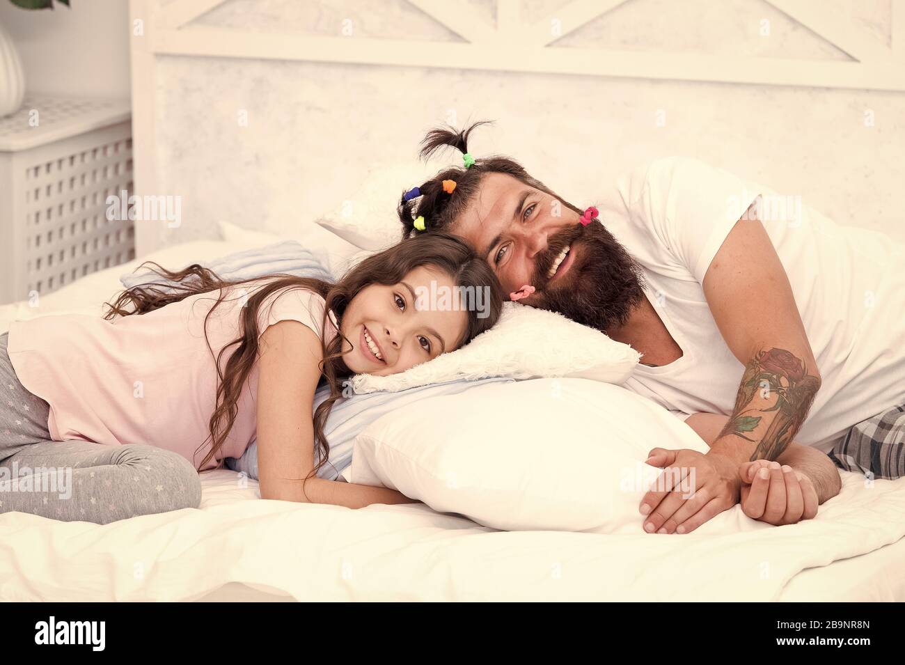 Enjoy better sleep at night. Bearded man put daughter to sleep. Tired child and father go to sleep. Bedtime routine. Got ready for bed. Good night. Sleep well. Stock Photo