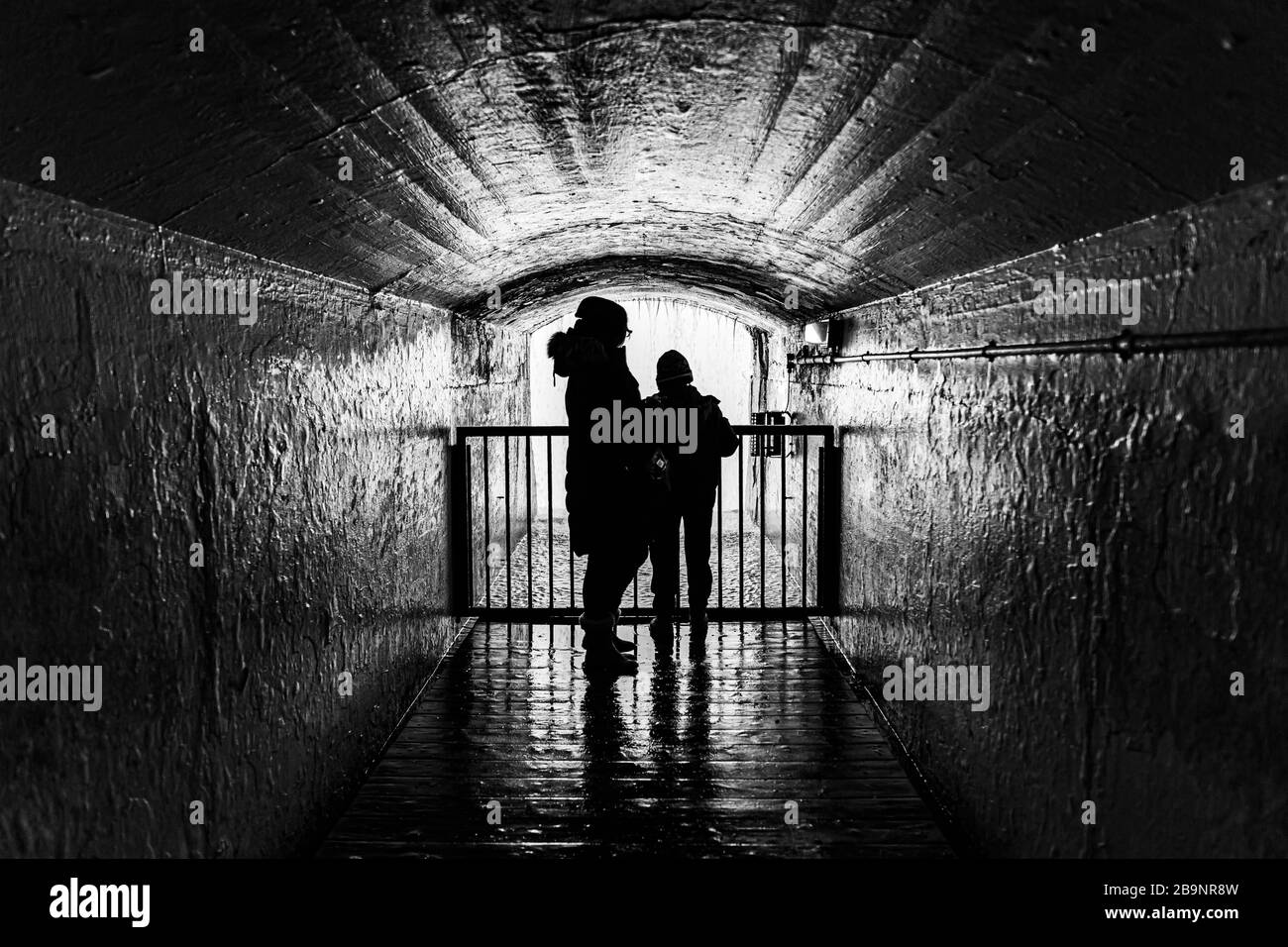 silhouette of mother and son in a tunnel Stock Photo