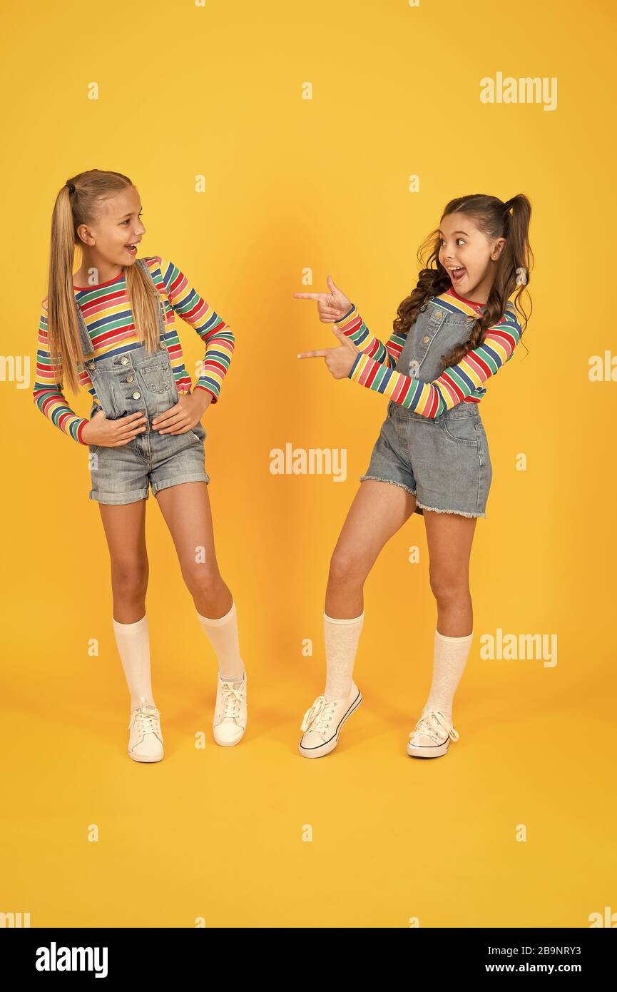 Little girls wearing rainbow clothes. Happiness. Girls long hair. Cute children same outfits communicating. Best friends. Trendy and fancy. Emotional kids. Fashion shop. Modern fashion. Kids fashion S...