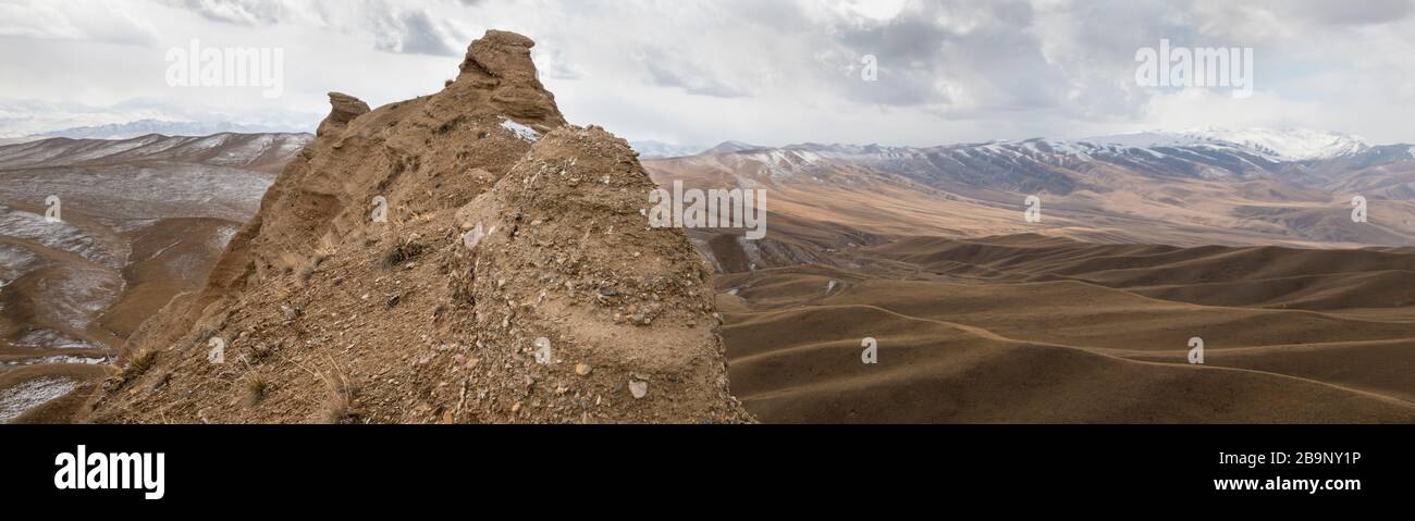 Landscape panorama of cahedral type rock mountain wall along the Kulak-Ashu pass connecting Baetov and Orto-Sirt with Tash-Rabat in Kyrgyzstan Stock Photo