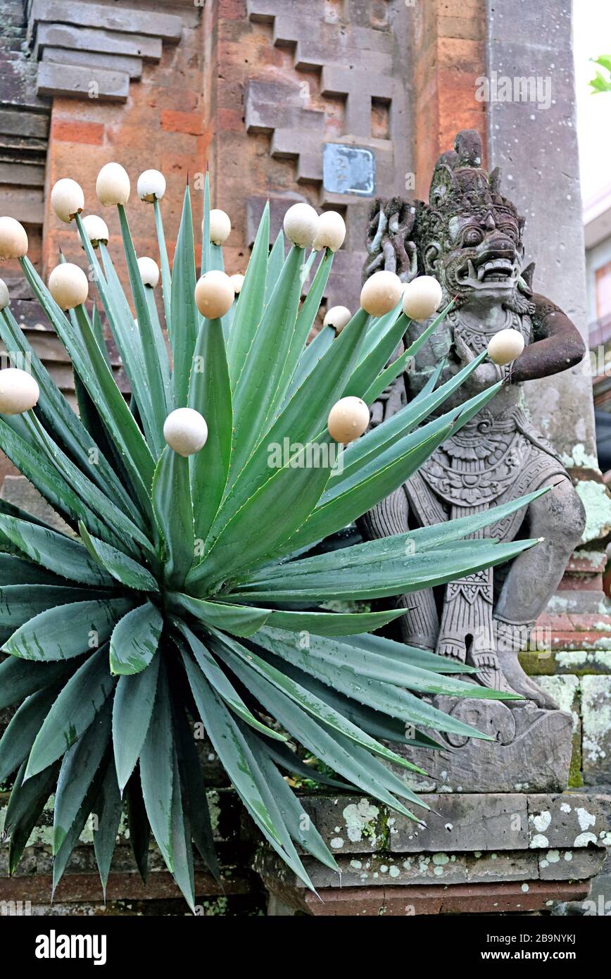 A stone entrance door decorated with stone statues of Balinese gods and