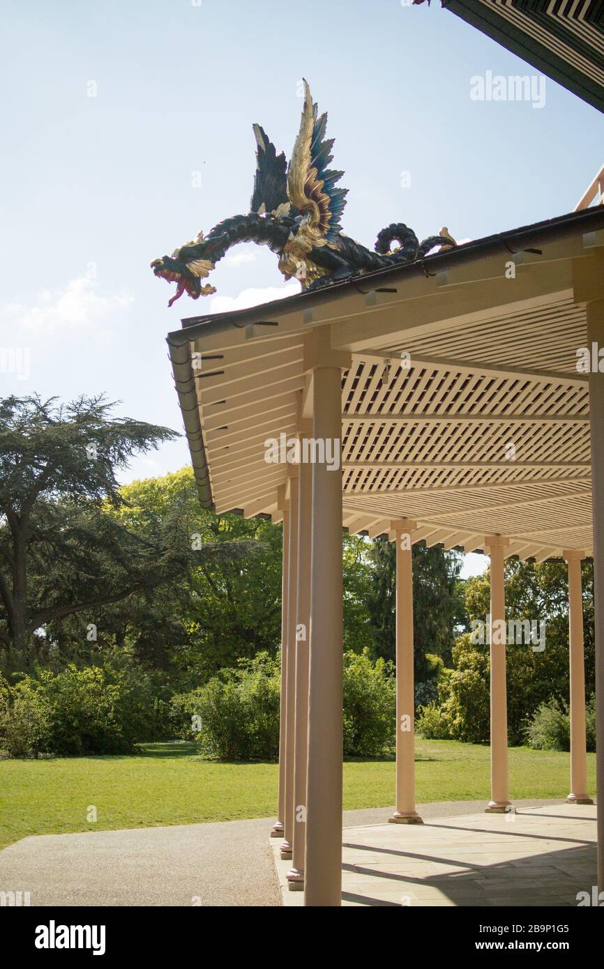 Ground floor of the restored Great Pagoda, designed by Sir William Chambers, showing profile of gilded wooden dragon against background of trees. Stock Photo