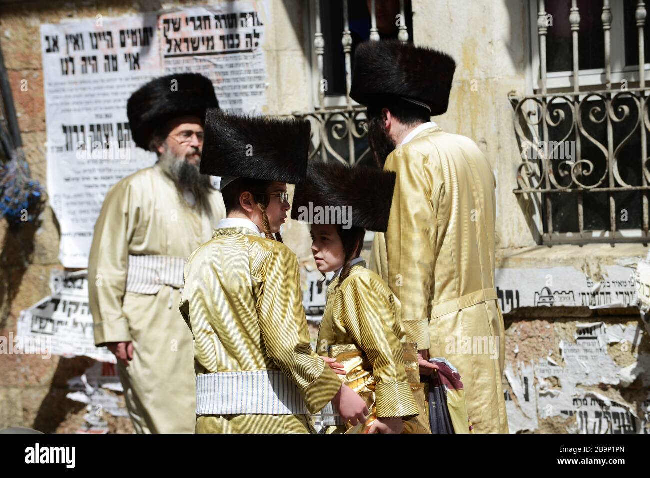 Jewish men wearing traditional shtreimel ( fur hat ) walking on Mea Shearim street on Purim festival day. Stock Photo