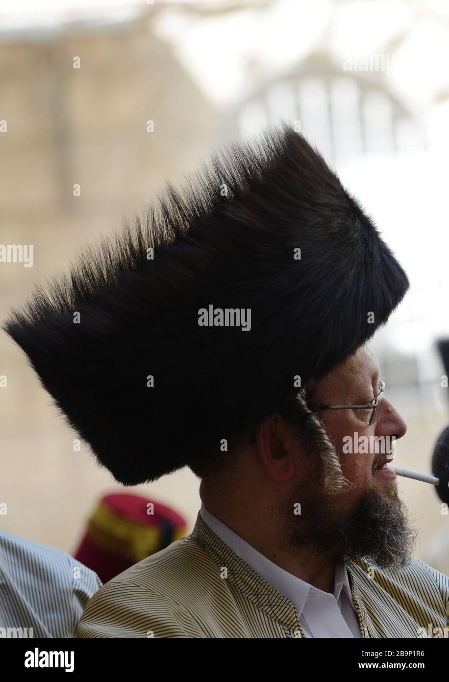 A Jewish Hasidic man wearing a Shtreimel ( traditional fur hat ) smoking a cigarette. Stock Photo