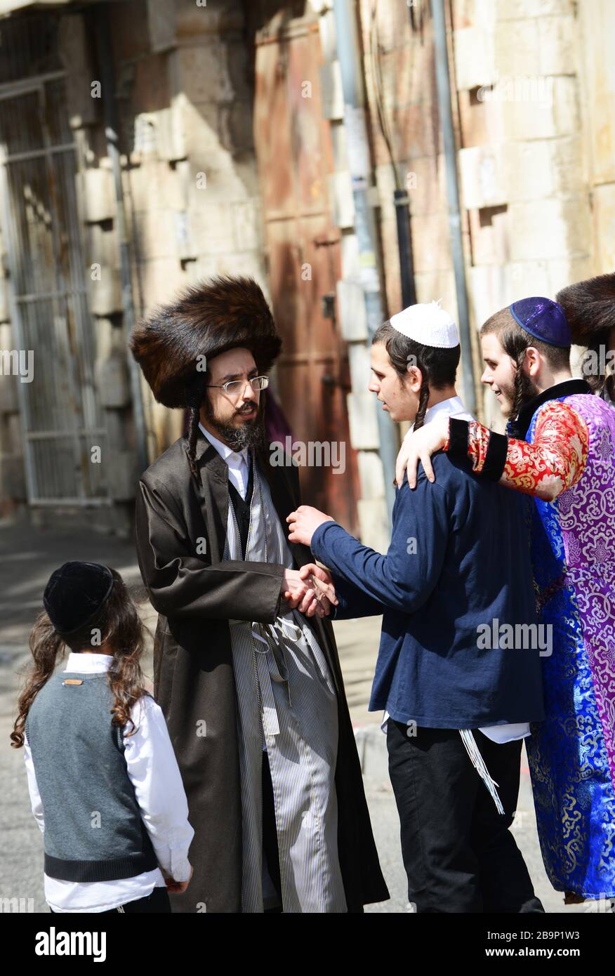 Jewish men wearing traditional shtreimel ( fur hat ) walking on Mea Shearim street on Purim festival day. Stock Photo