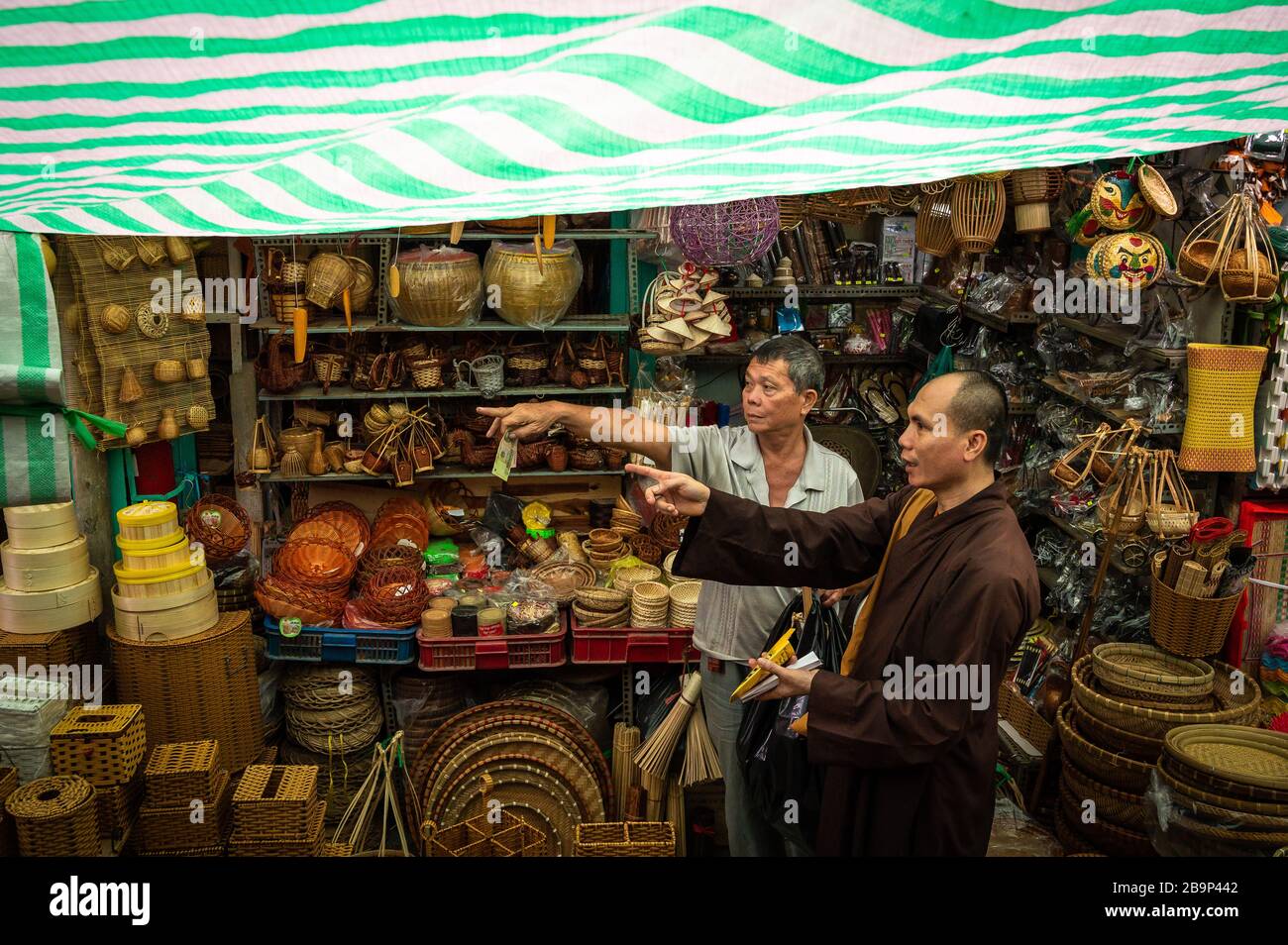 A shopkeeper giving directions in Binh Tay Market, Ho Chi Minh, Vietnam. Stock Photo