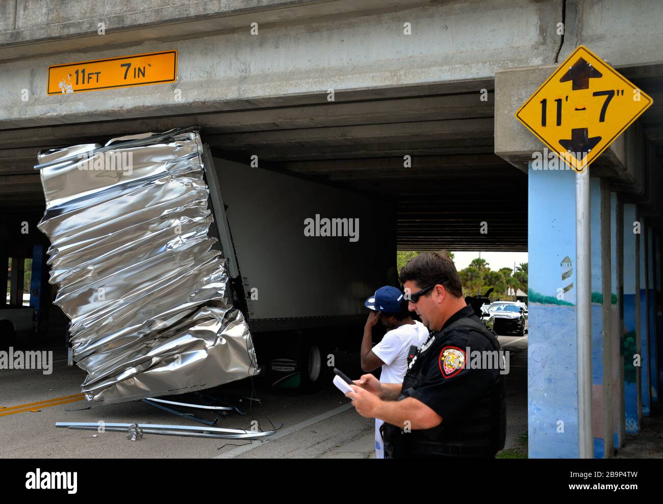 Melbourne, Florida, USA. March 24, 2020. Melbourne Police Department closed off a section of Melbourne Ave. due to an oversize box truck getting stuck under the US1 overpass. Melbourne Fire Department deflated the trucks tires so that the truck could be removed from the bridge. State DOT and Road and Bridge inspected the bridge for damage. Credit: Julian Leek/Alamy Live News Stock Photo