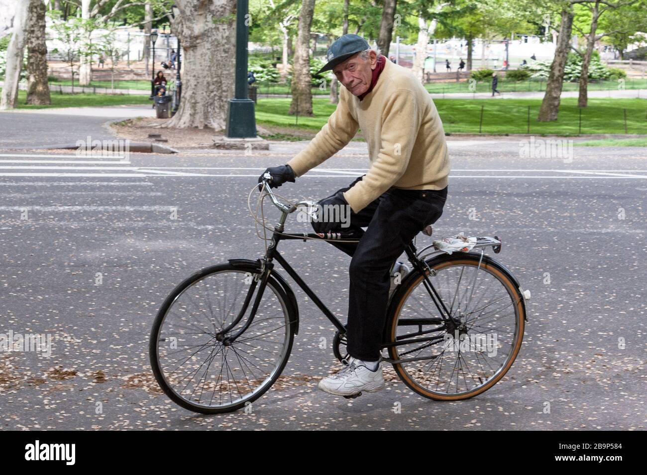 An older man rides his bike in Central Park in New York City. Stock Photo