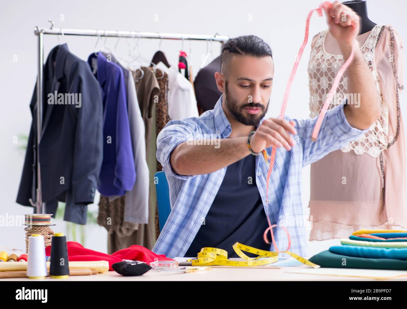 The male tailor working in the workshop on new designs Stock Photo - Alamy