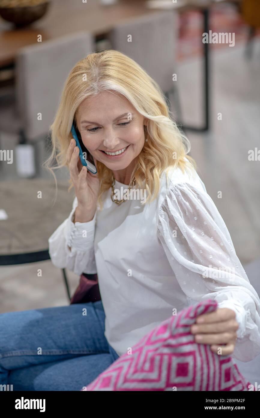 Good looking woman sitting looking over patterned pillow Stock Photo ...