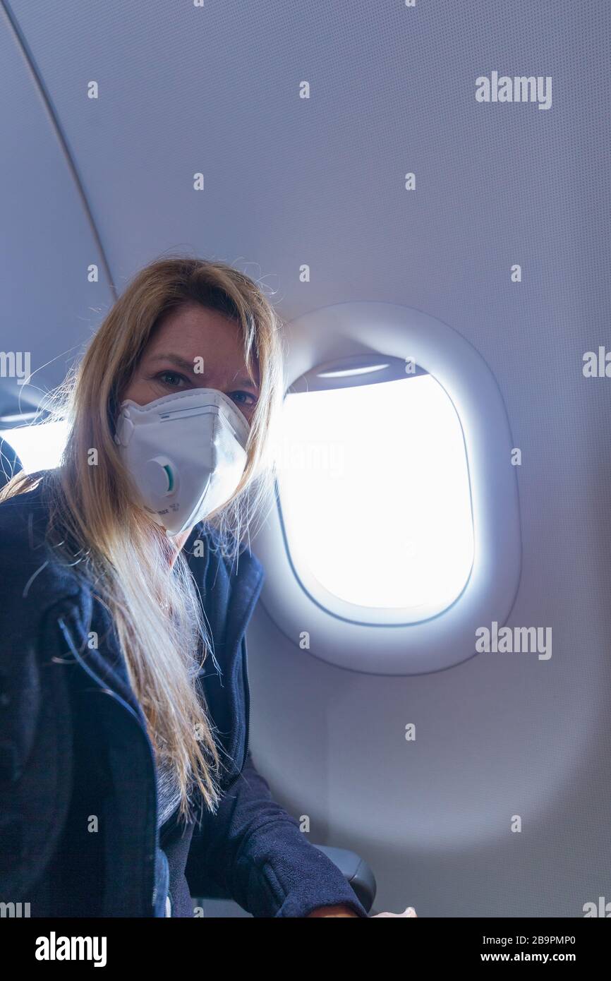 Flying during a global pandemic - woman with face mask Stock Photo