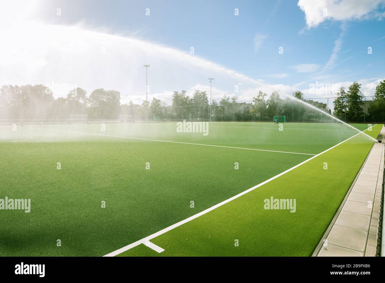 Sports field is watered by a sprinkler system Stock Photo