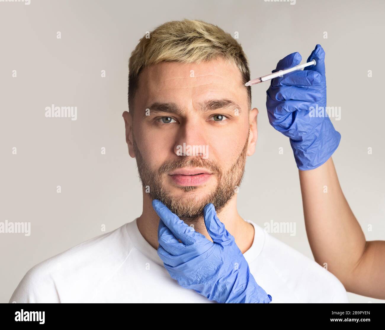 Handsome man takes beauty injections in clinic Stock Photo
