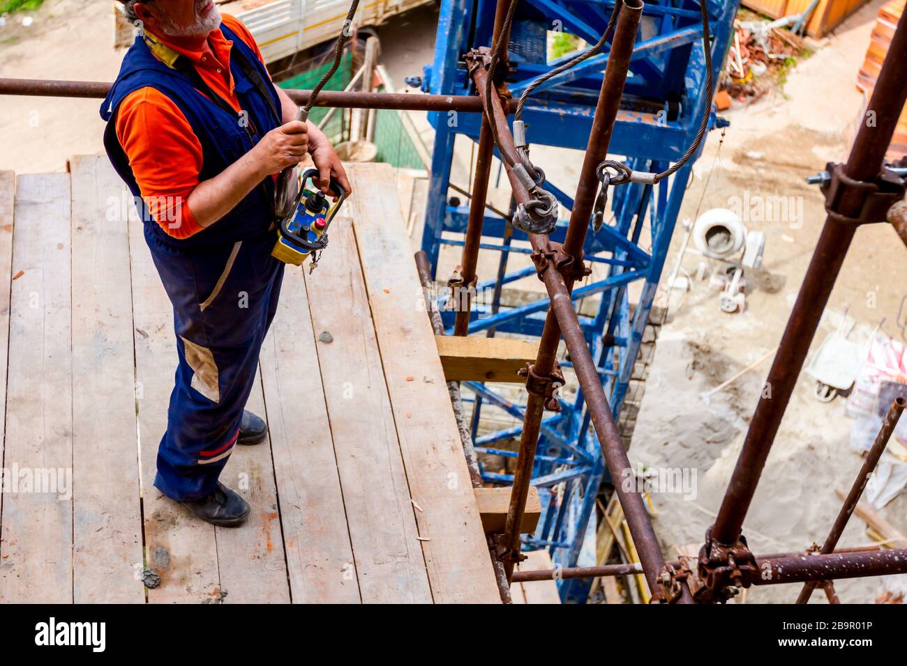 Operator, worker is holding industrial remote, wireless, console to control  overhead crane with joystick at construction site Stock Photo - Alamy