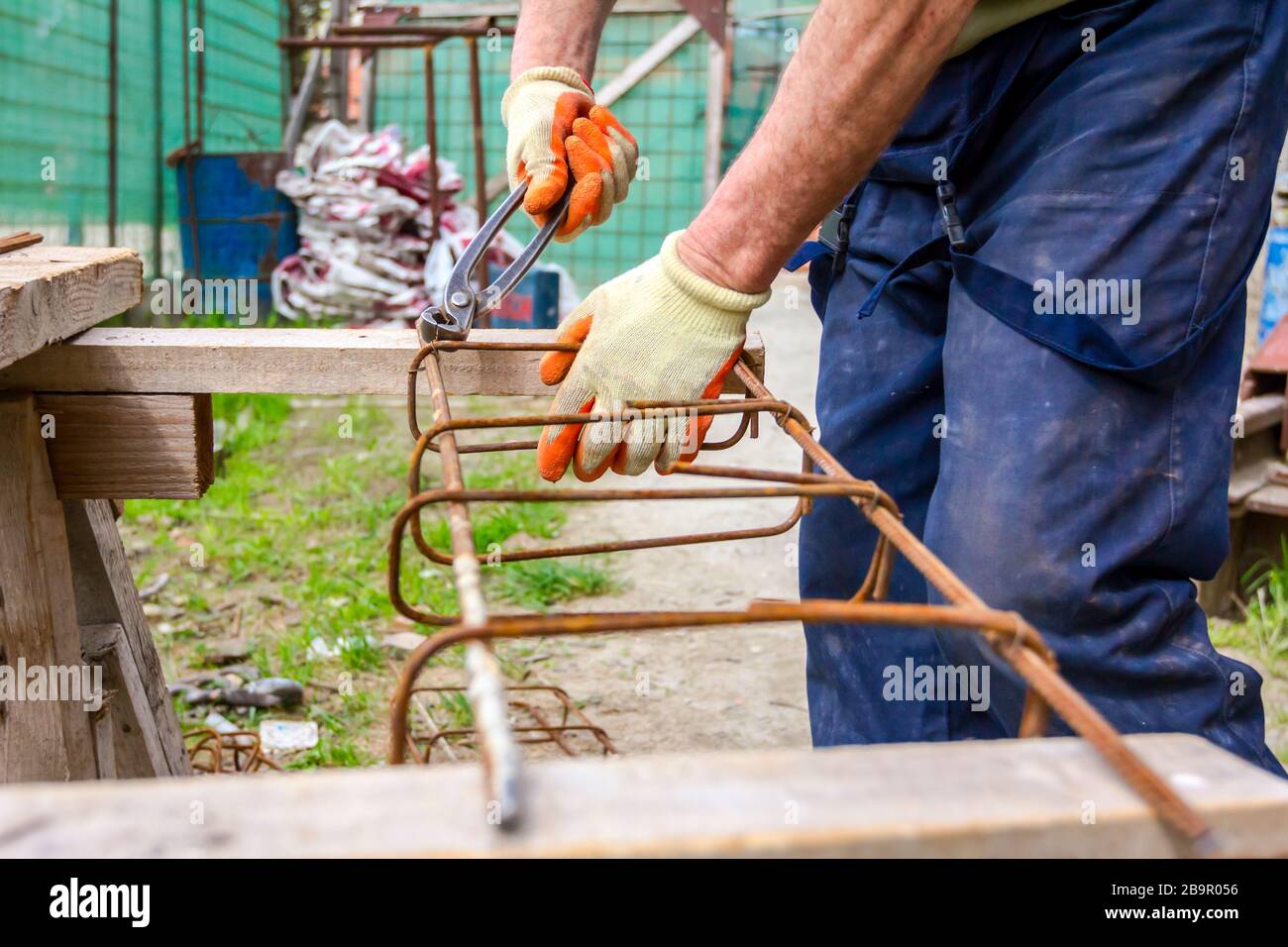 Worker is tying rebar with wire using pliers, to make a reinforcing