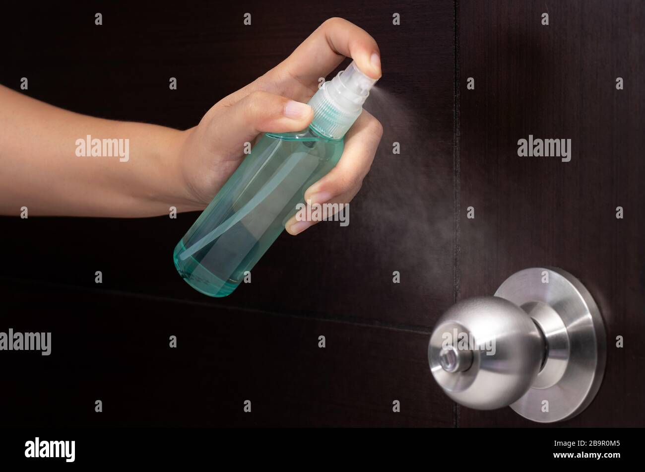 disinfect, sanitize, hygiene care. inject alcohol spray on door knob and frequently touched area for cleaning and disinfection, prevention of germs sp Stock Photo