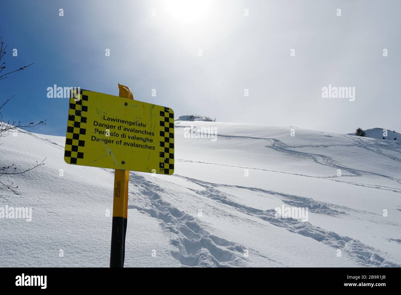 A sign post or signpost warning from avalanches in German, French, Italian and English, in skiing resort, Hoch Ybrig in Switzerland Stock Photo