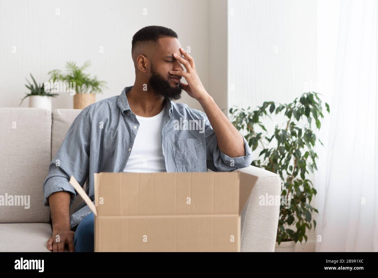 Disappointment in online shopping concept. Guy presses hand to face Stock Photo