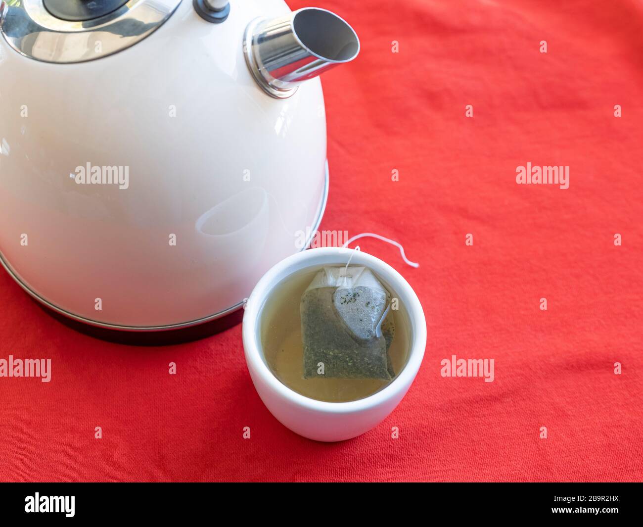 Electric kettle with boiling water for the herbal tea. Tea bag in a