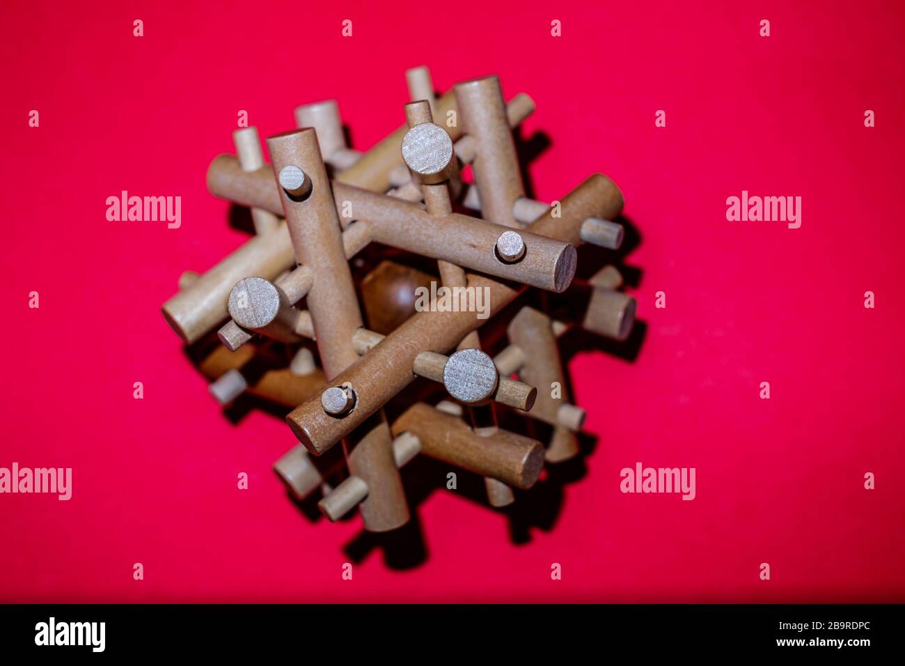 Wooden Brain Bamboo Puzzle on red background Stock Photo - Alamy