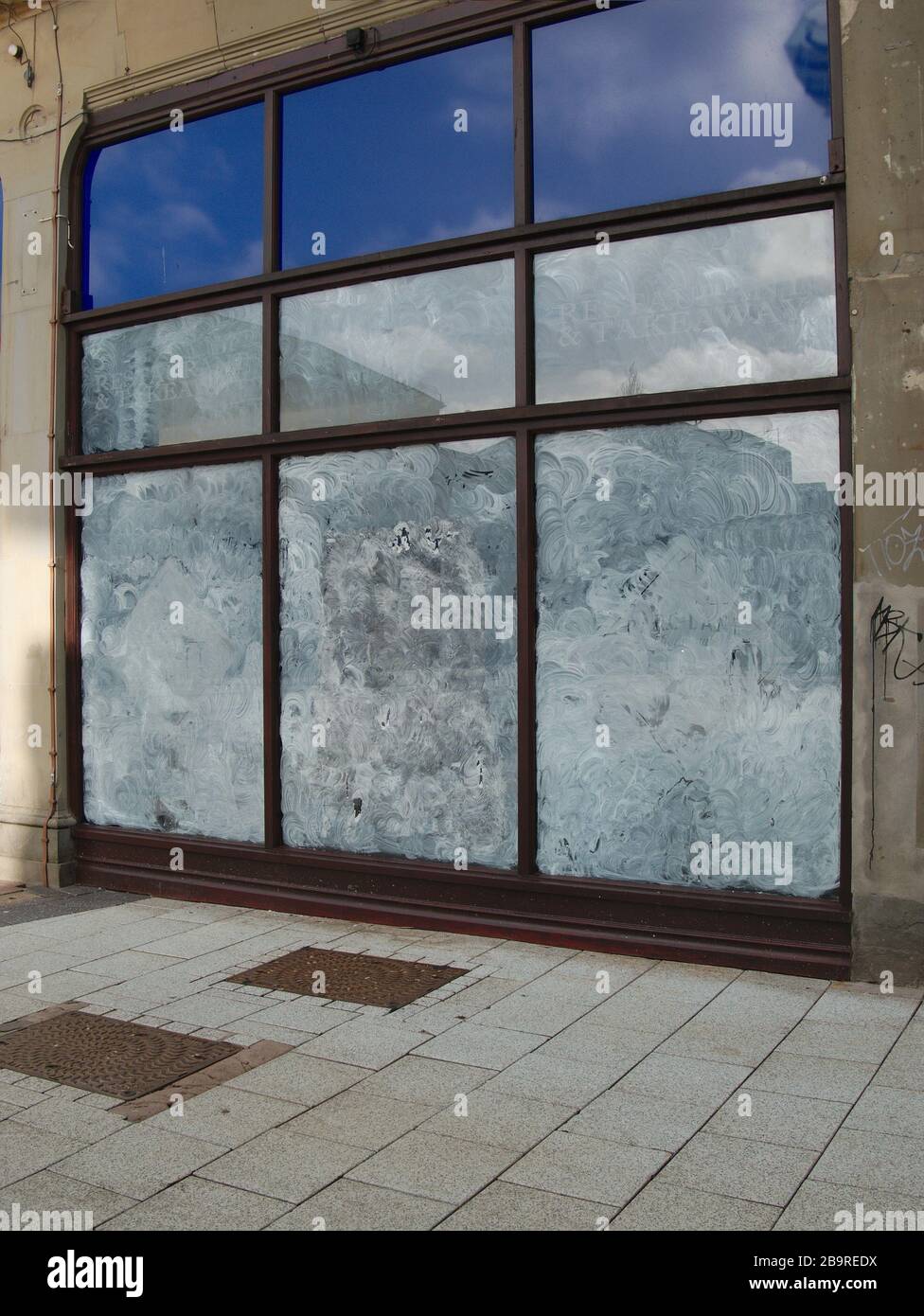 whitewashed shop windows of closed high street retail business. Stock Photo