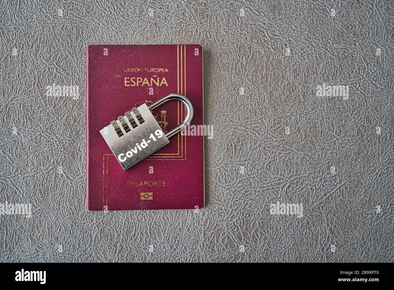 Spanish international passport blocked with a padlock due to the coronavirus pandemic, covid 19. Symbology for the closure of borders and the transfer Stock Photo