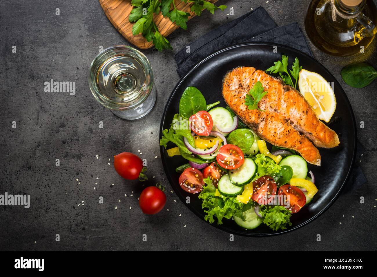 Grilled salmon fish steak with vegetables on black Stock Photo - Alamy