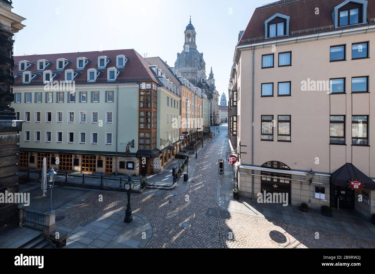 Dresden, Germany. 25th Mar, 2020. The Münzgasse to Neumarkt with the Frauenkirche is deserted (l). To contain the coronavirus, Saxony now prohibits all accumulations of three or more people in public. Credit: Robert Michael/dpa-Zentralbild/dpa/Alamy Live News Stock Photo