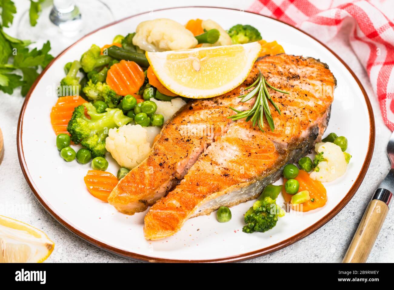 Grilled salmon steak with vegetables on white Stock Photo - Alamy