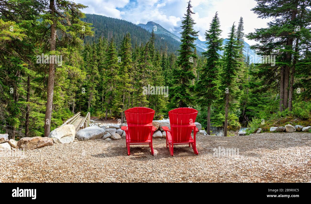 Two red wooden chairs with a view on the mountains in Glacier National park, Rocky Mountains, Bristish Columbia, Canada Stock Photo