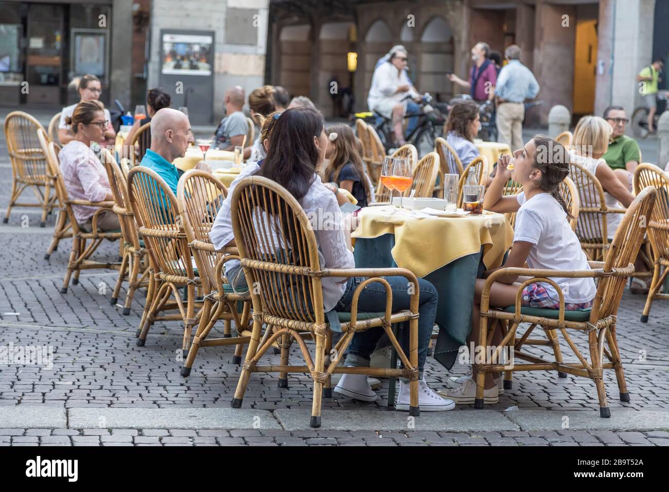 CREMONA, ITALY - SEPTEMBER 02, 2015: People sit at little tables in street cafe on Piazza del Comune in Cremona. Italy Stock Photo