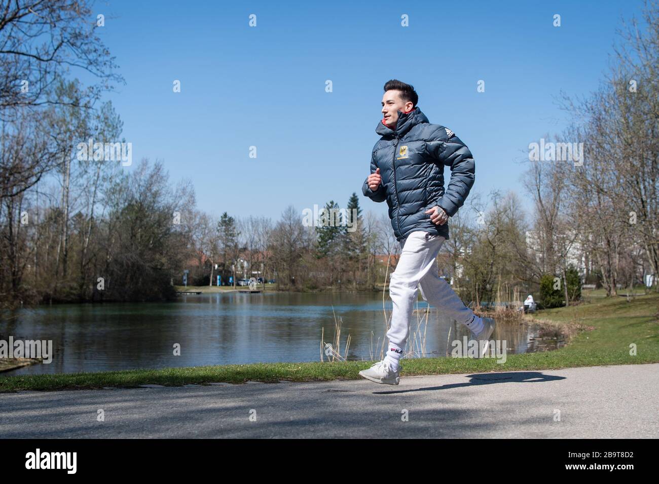 Unterhaching, Germany. 24th Mar, 2020. Marcel Nguyen, jogging at a lake. Due to the corona virus, training in the gym is currently only possible to a limited extent or even not