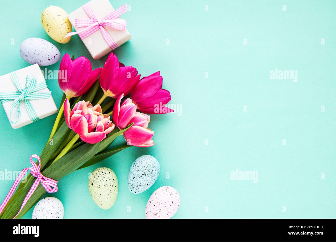 Spring tulip flowers, Easter eggs and gift box on pastel green ...