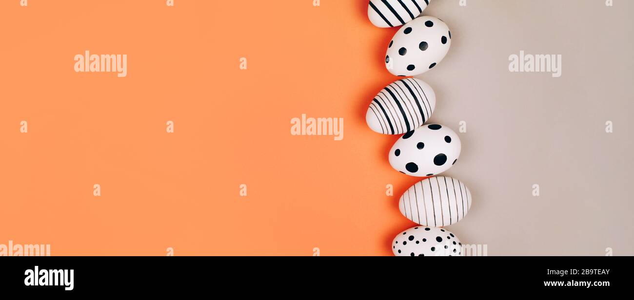 Easter eggs dotted on multicolored background. Festive concept. Flat lay style Stock Photo