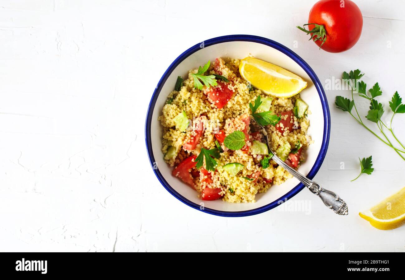 Lemon couscous. Couscous with tomato, cucamber, lemon and herbs. Traditional Arabic Salad Tabbouleh Stock Photo