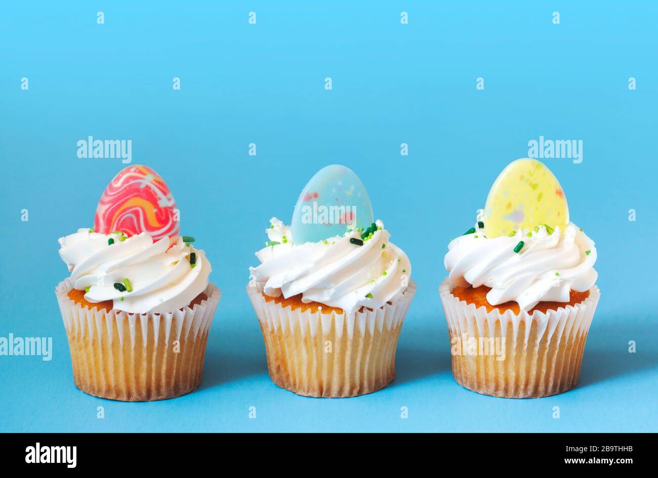 Easter vanilla cupcakes on blue background Stock Photo