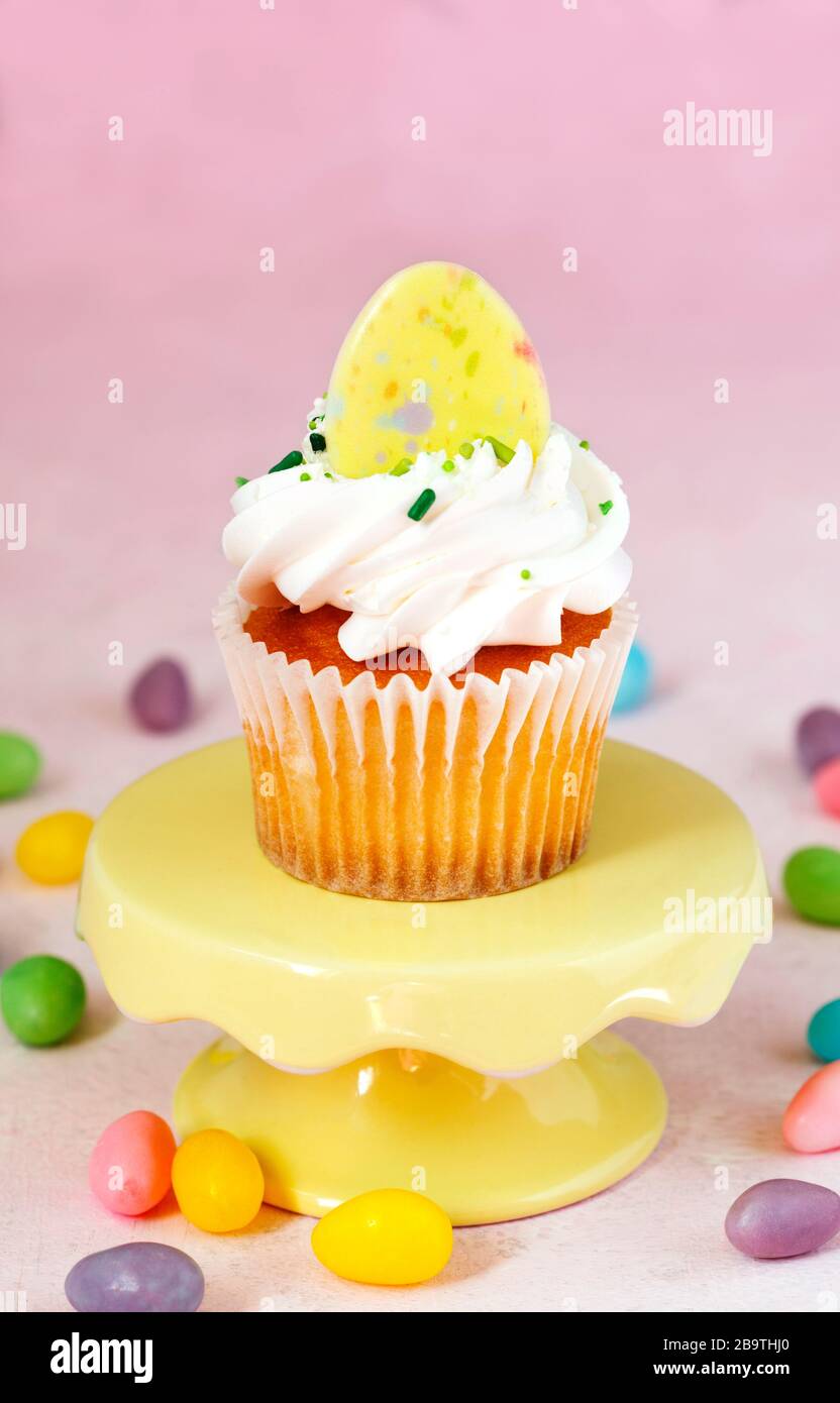 Cupcake on a cake stand on pink background Stock Photo