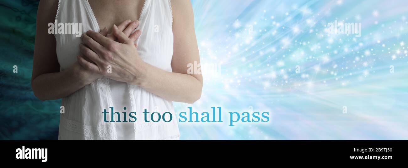 And this, too, shall pass concept banner - female with hands over heart against a dark and light spiritually uplifting background Stock Photo