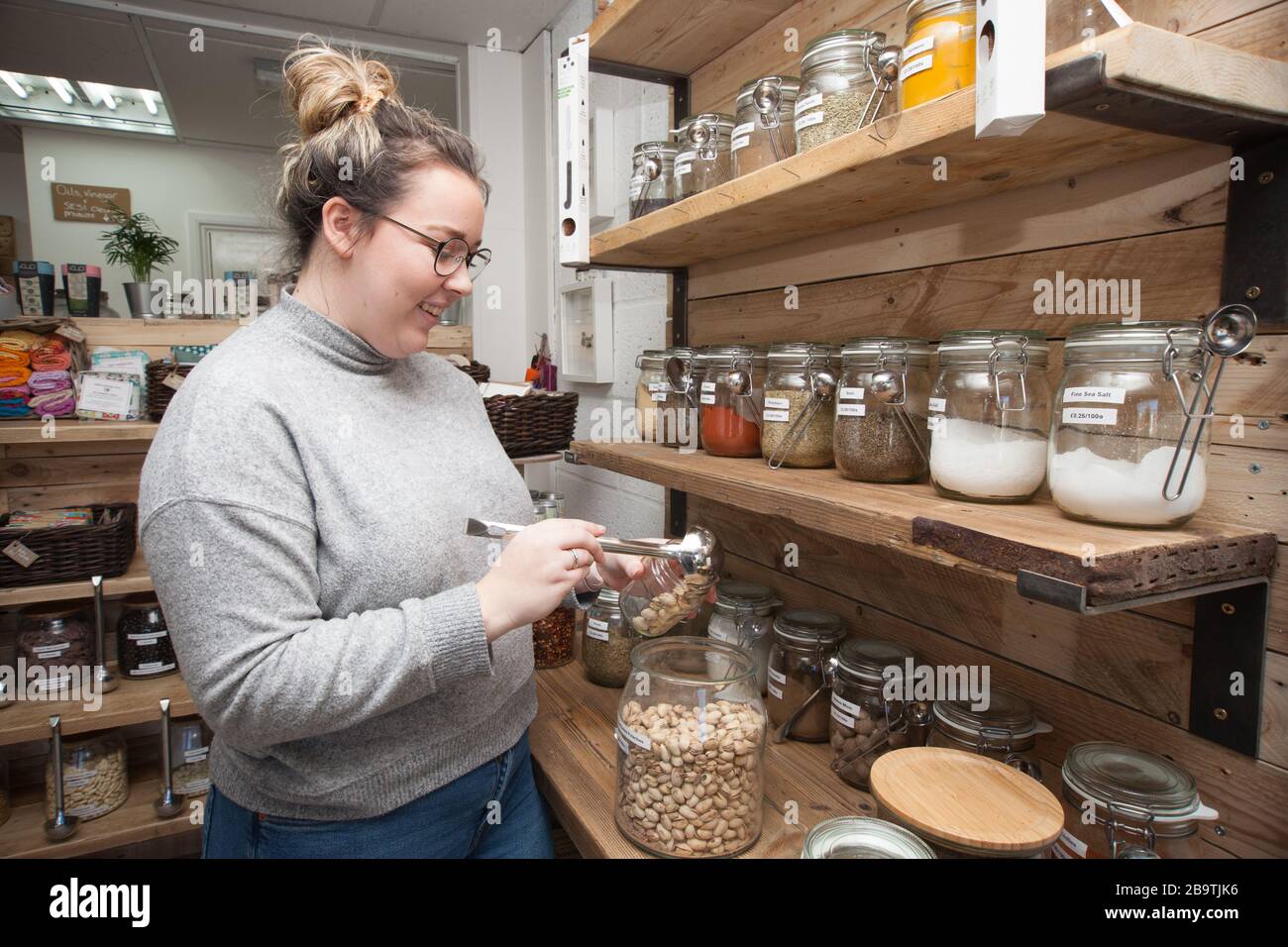 A shopkeeper working in her zero waste store in the UK Stock Photo
