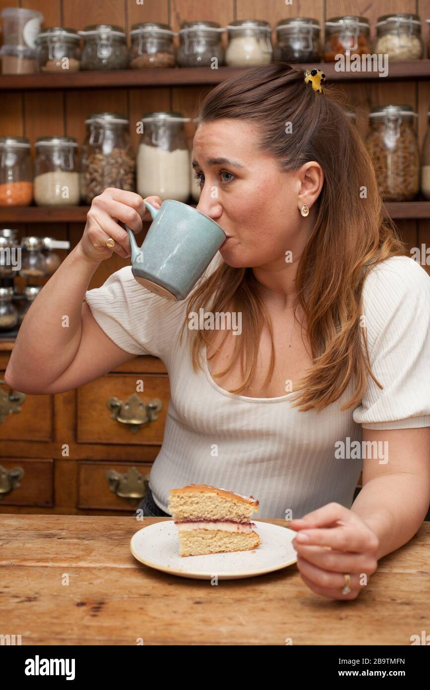A woman in her 30s drinking a mug of coffee Stock Photo