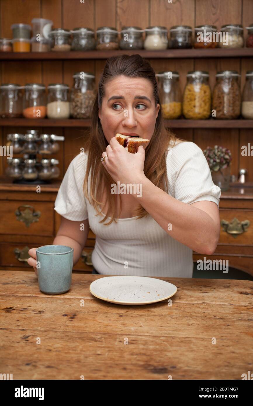 A woman in her 30s eating a slice of cake Stock Photo