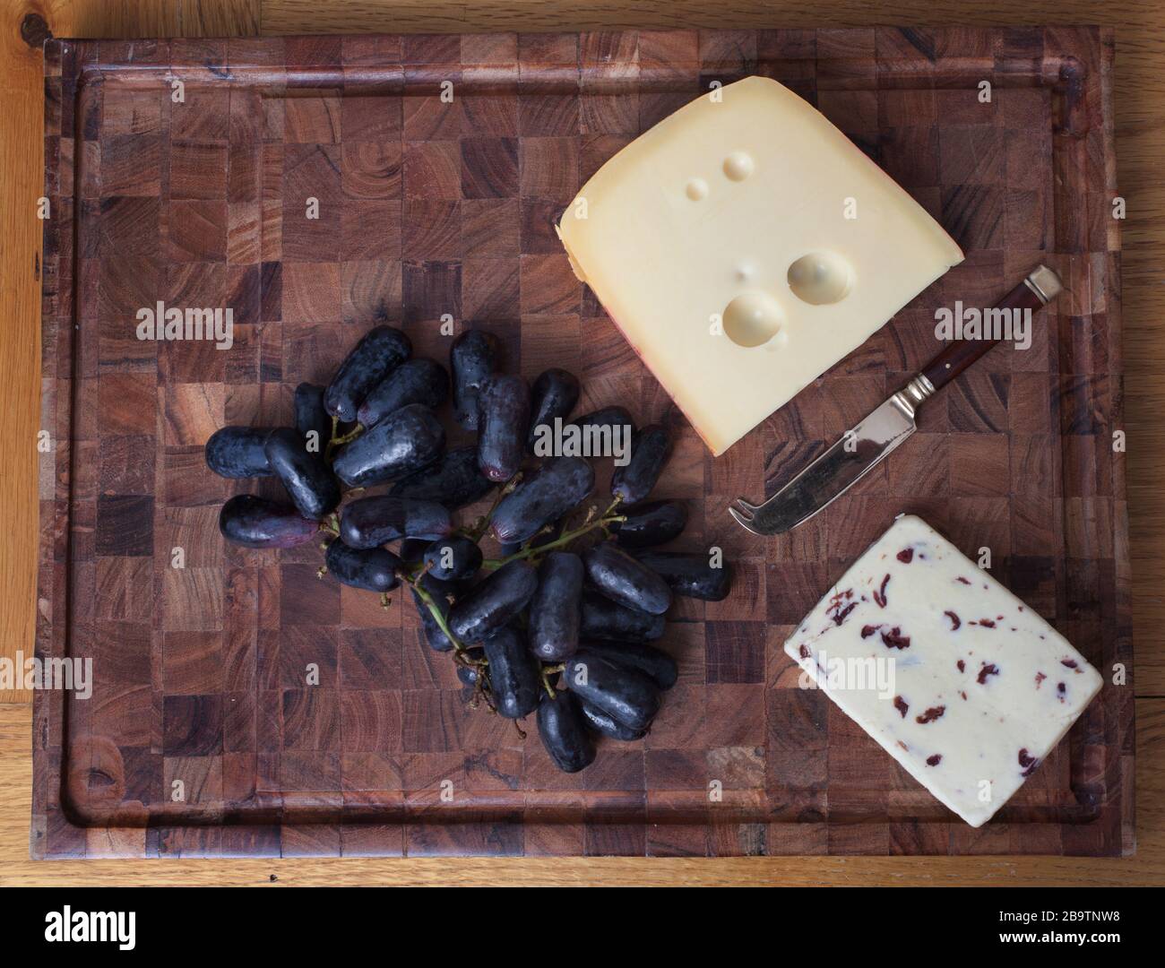 British Wensleydale and Norwegian Jarlsberg cheese with long black sweet grapes Stock Photo