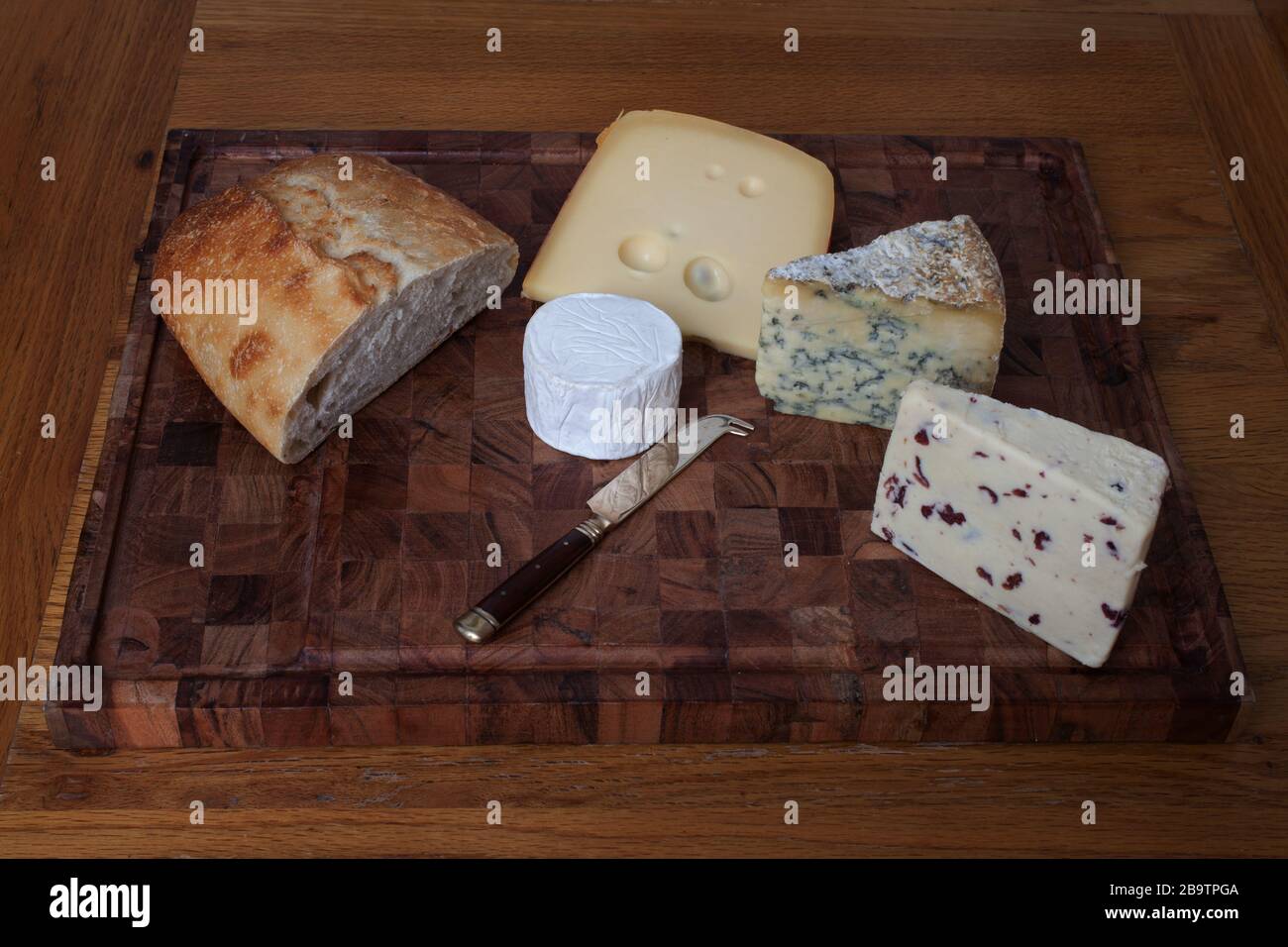 Sourdough with Wensleydale, Stilton, Jarlsberg and goat's cheese on a chopping board Stock Photo