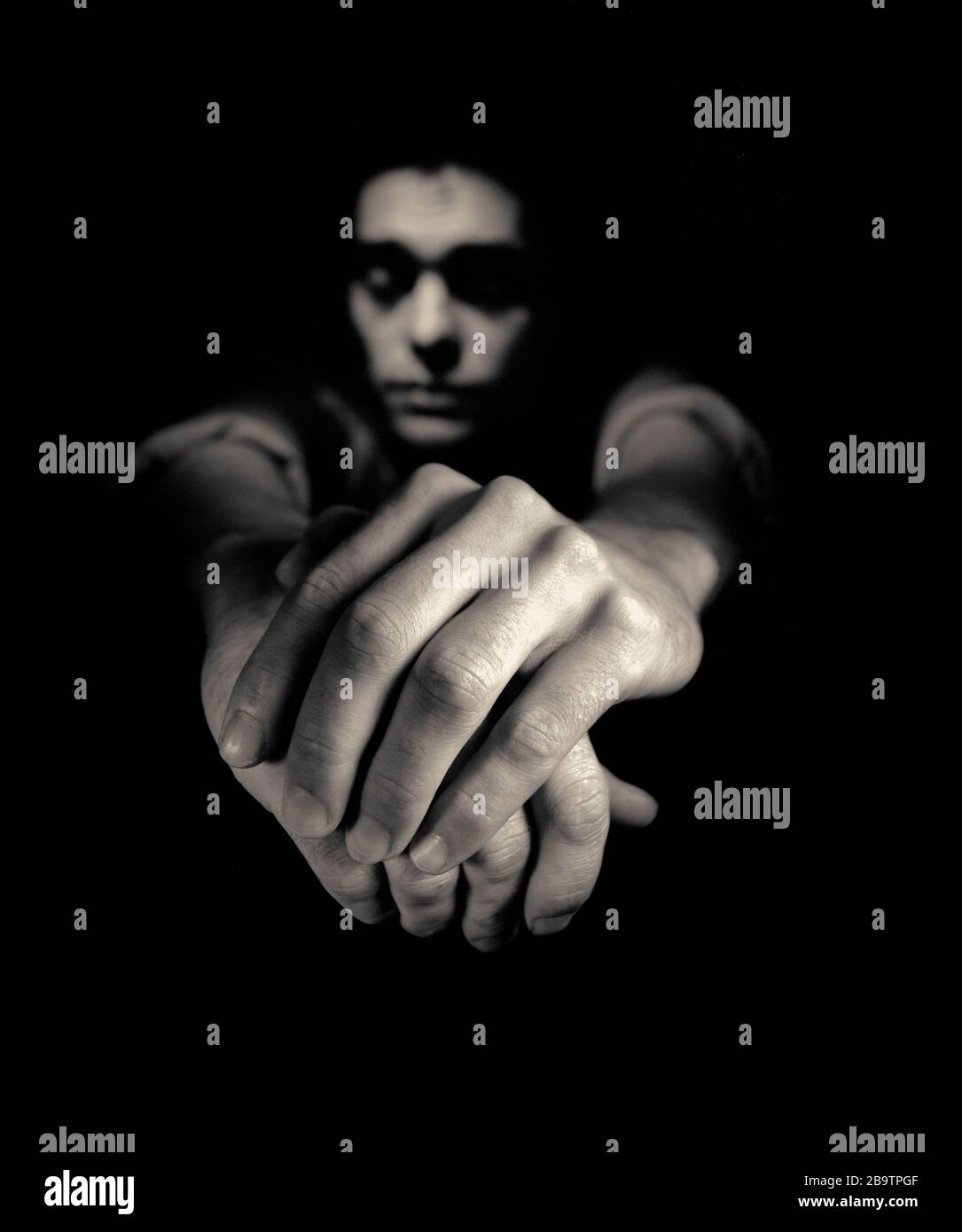 black and white man clasping hands to camera Stock Photo - Alamy